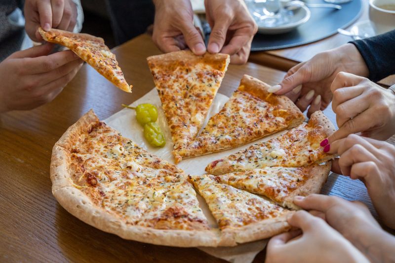 Dewey's pizza chef preparing artisan pizza in the kitchen
